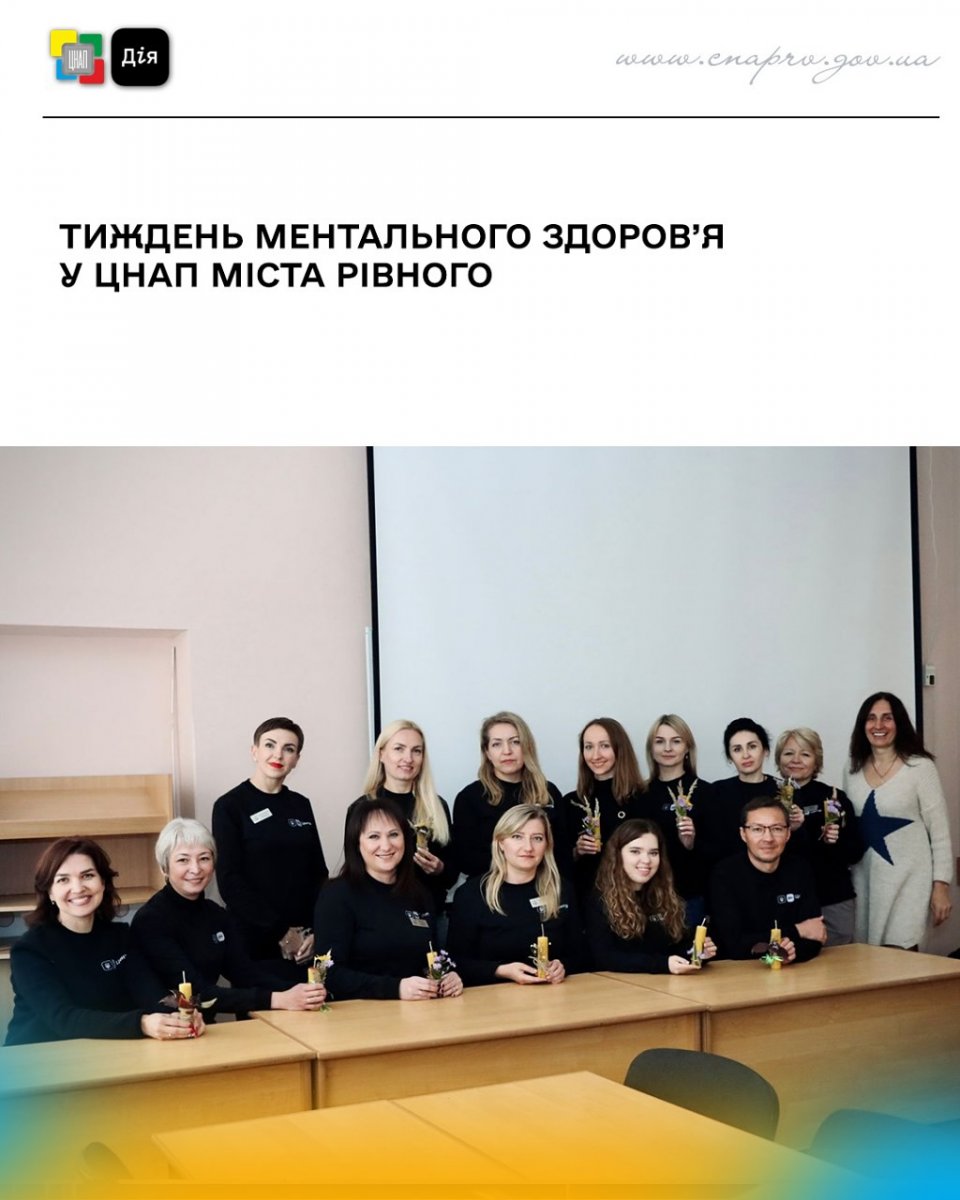 Групове фото у приміщенні, люди тримають у руках свічки та посміхаються.