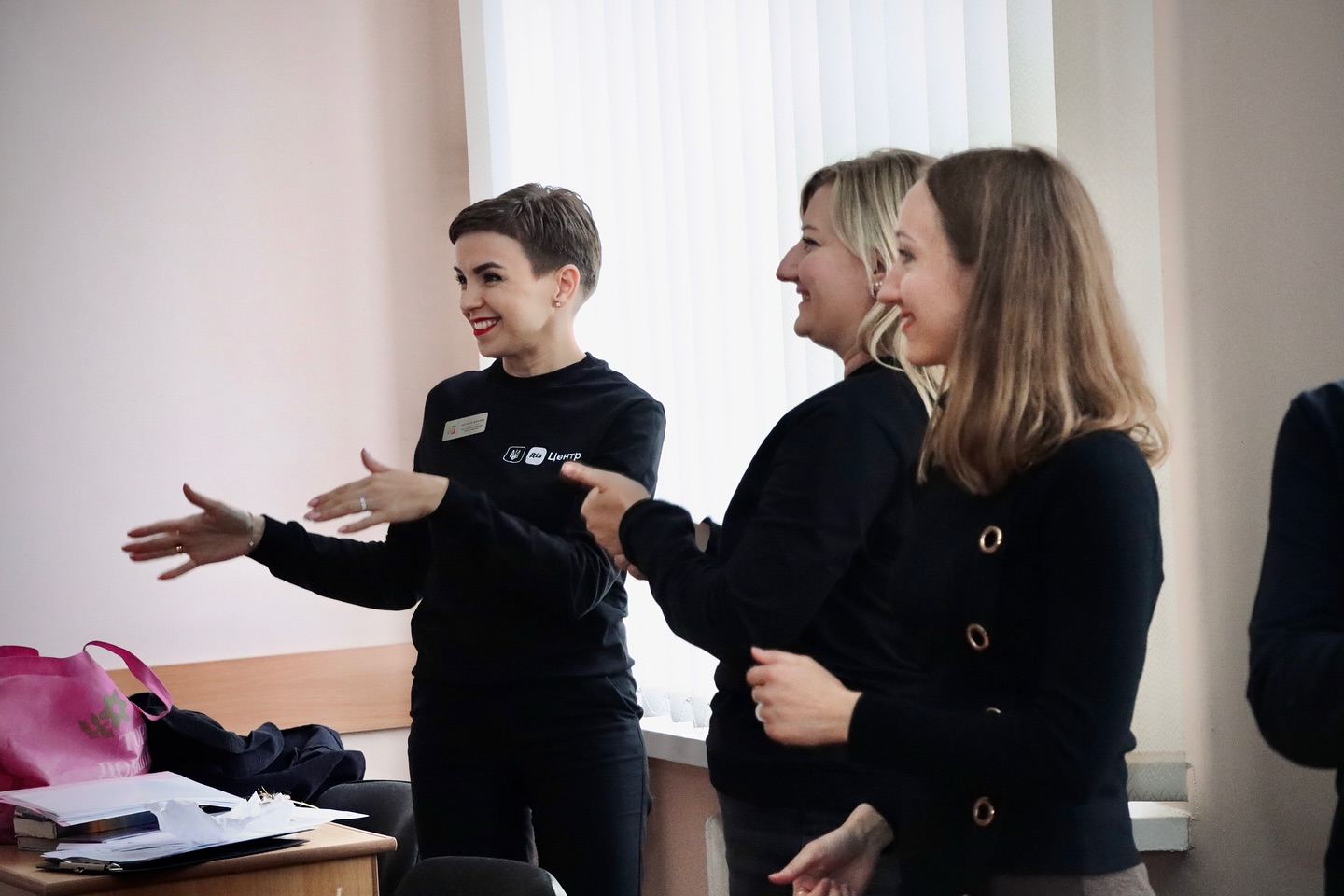 Троє жінок стоять і усміхаються