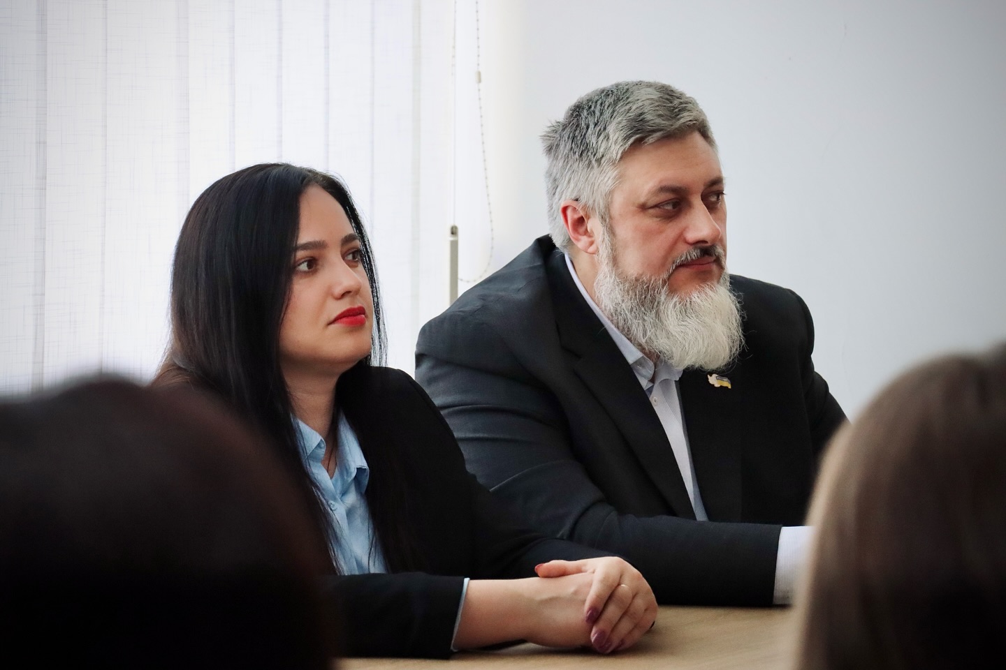 Чоловік та жінка сидять у приміщенні.
