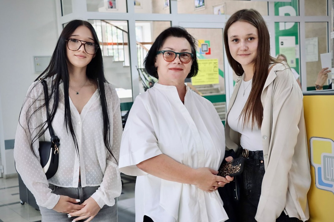 Дві дівчини та жінка позують для фото.