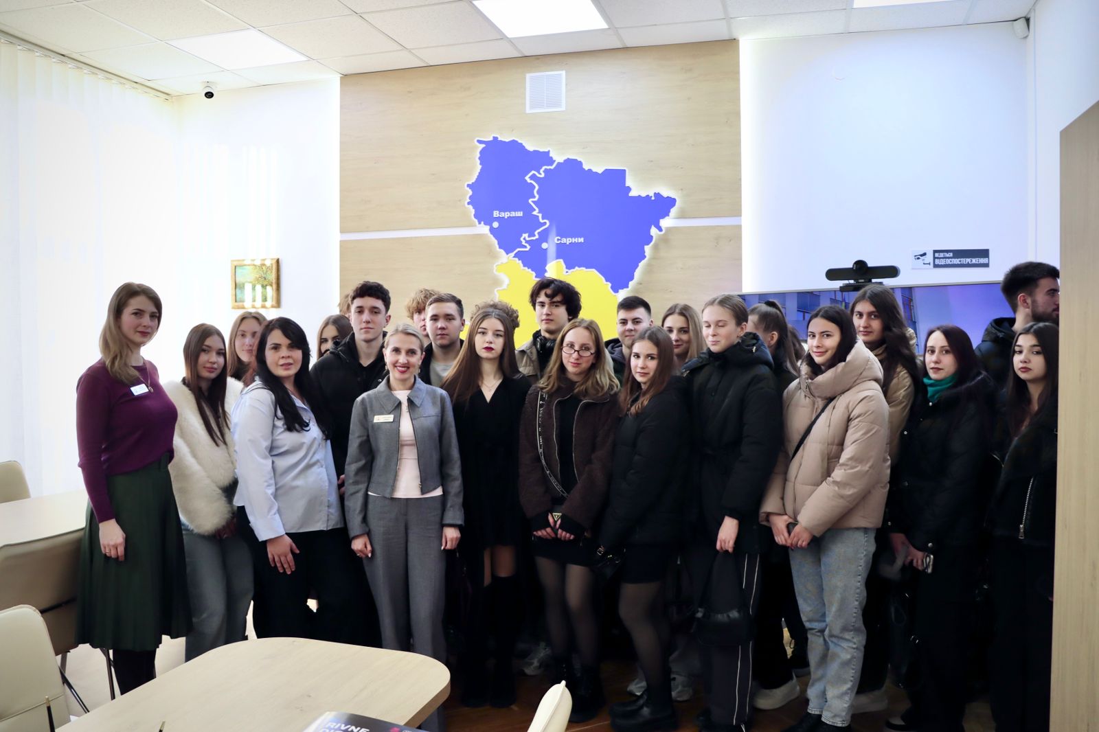 Група людей позує для фото у приміщенні.