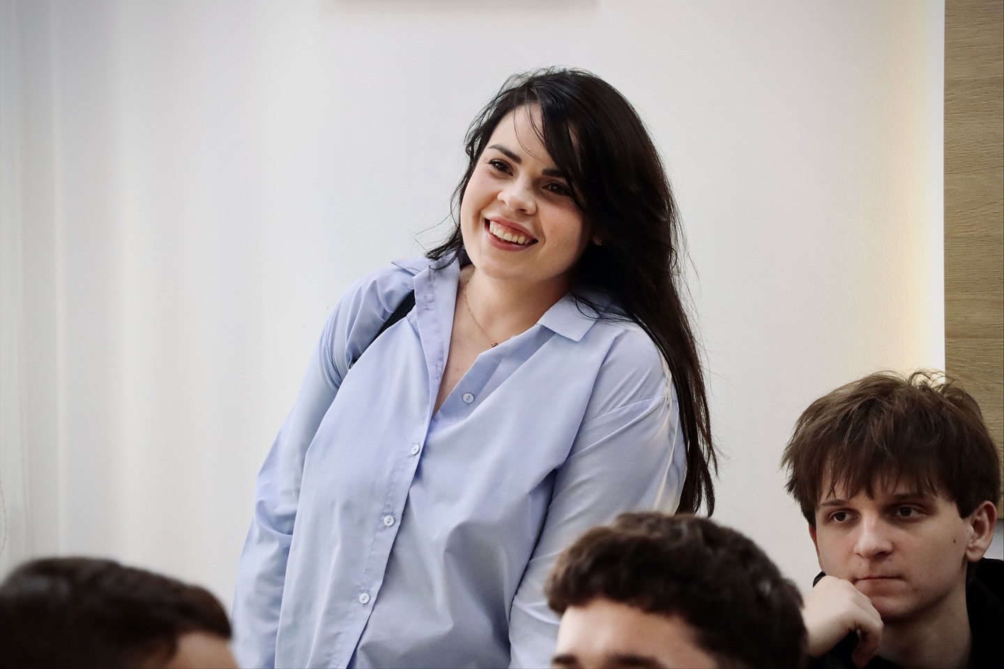 Жінка з темним волоссям посміхається.