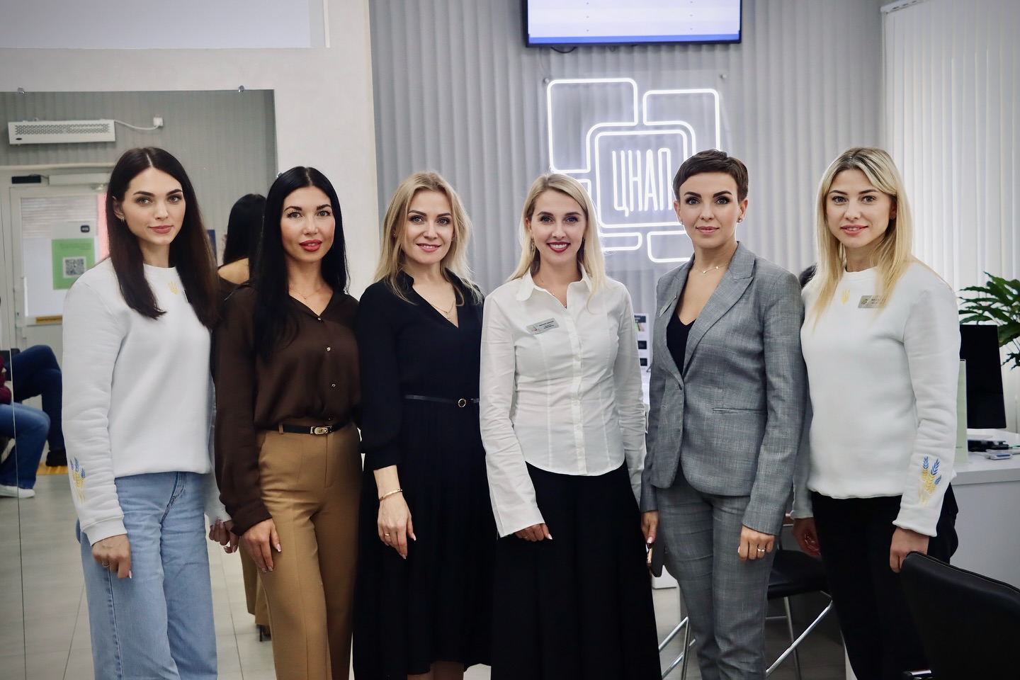 Шість жінок позують для фото перебуваючи у приміщенні