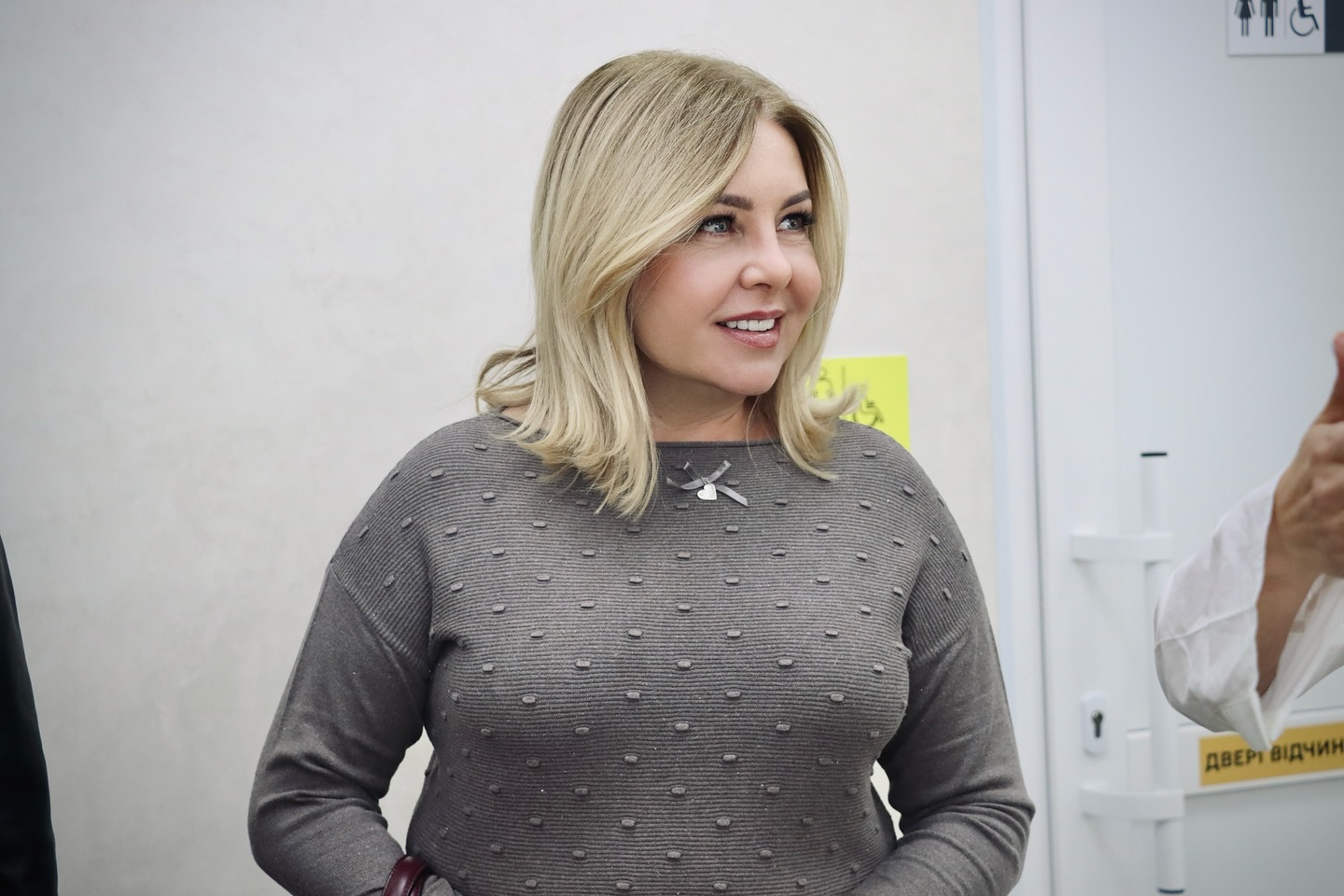 Жінка із світлим волоссям перебуває у приміщенні