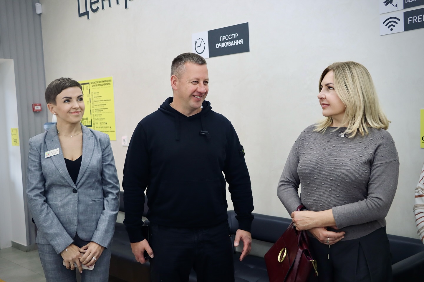 Дві жінки та чоловік перебувають у приміщенні