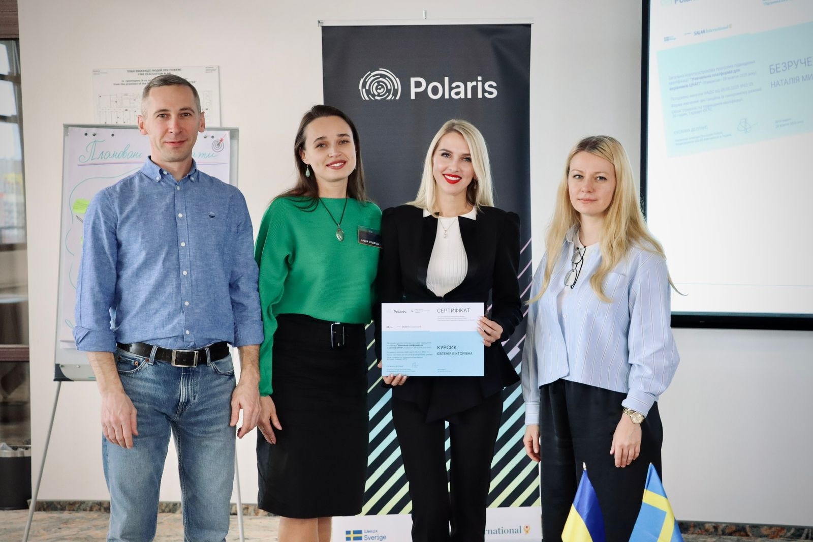 Три жінки та чоловік позують для фото