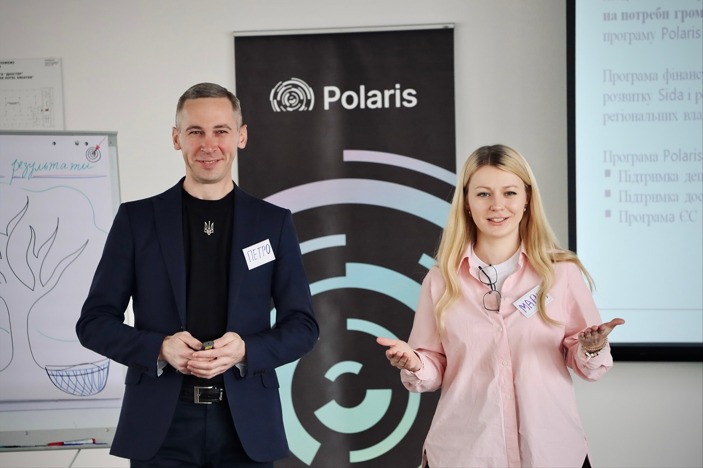 Чоловік жінка стоять у приміщенні.