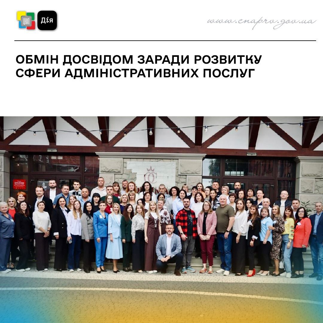 Групове фото людей, на задньому фоні - будівля.