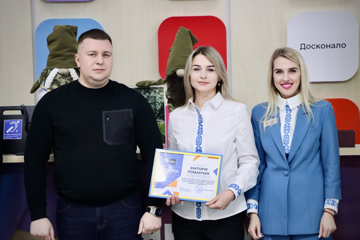 Дві жінки зі світлим волоссям та чоловік перебувають у приміщенні.