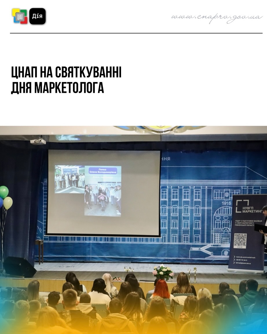 Глядачі сидять в залі, на сцені екран із зображенням.