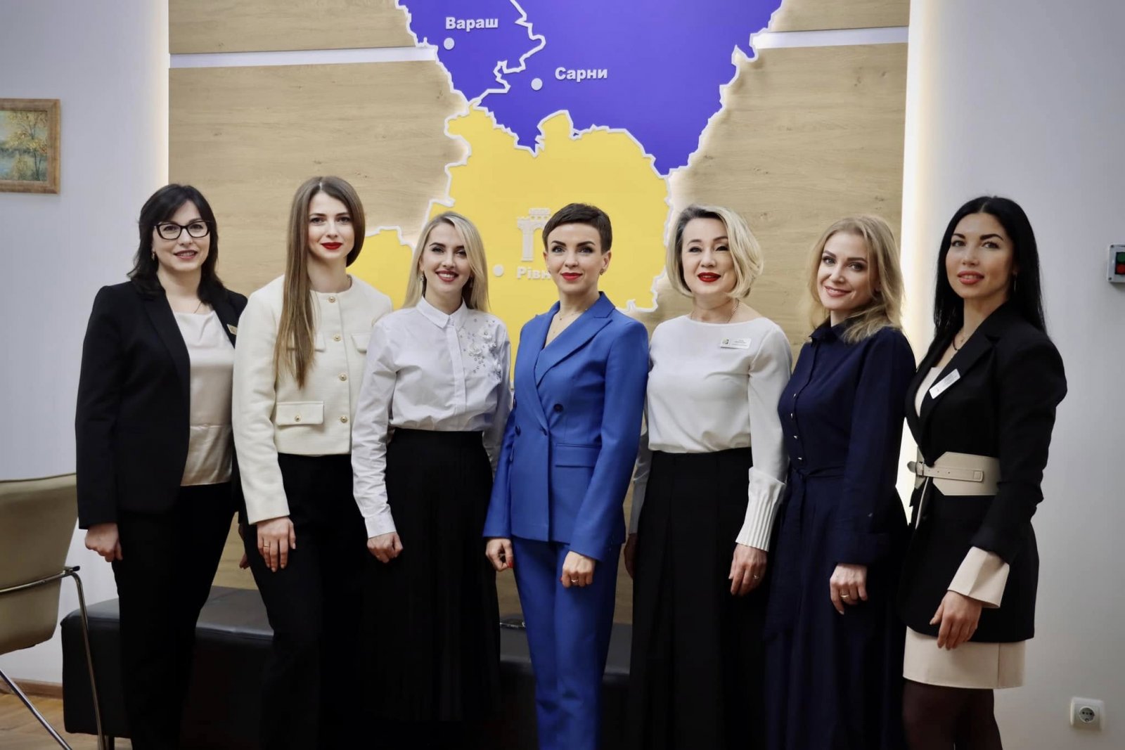 Жінки стоять у кабінеті та посміхаються. На задньому фоні видно карту Рівненської області.