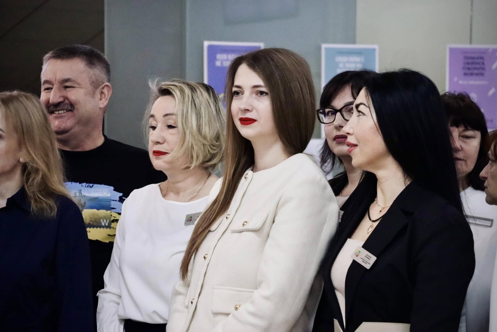 Люди знаходяться у приміщені  ЦНАПу в місті Рівному. Вони посміхаються.