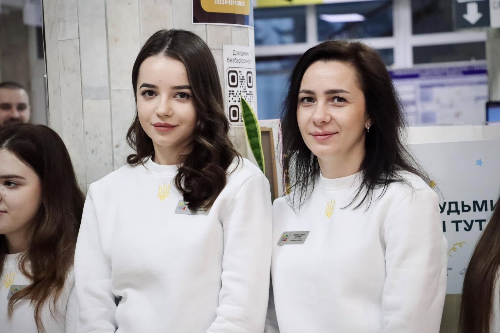 Жінки у білих кофтах знаходяться у приміщені  ЦНАПу.