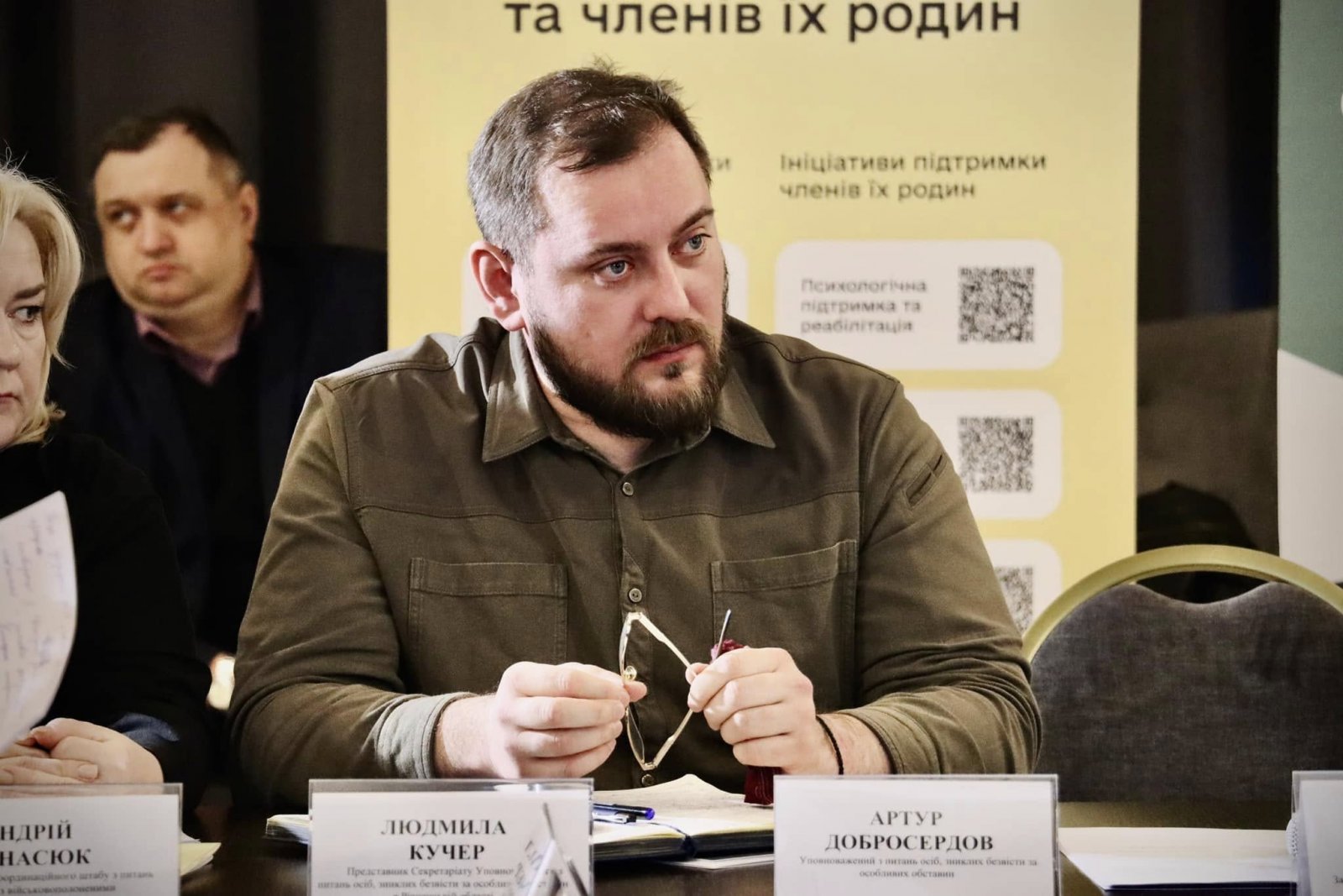 Чоловік та жінка сидять за столом. Вони беруть участь у діалоговій зустрічі.