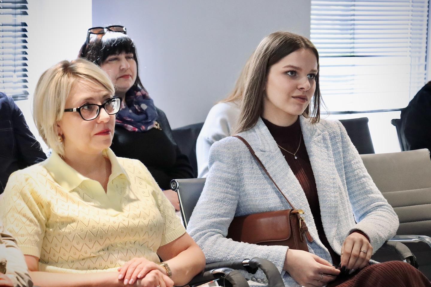 Дві жінки сидять у приміщенні.