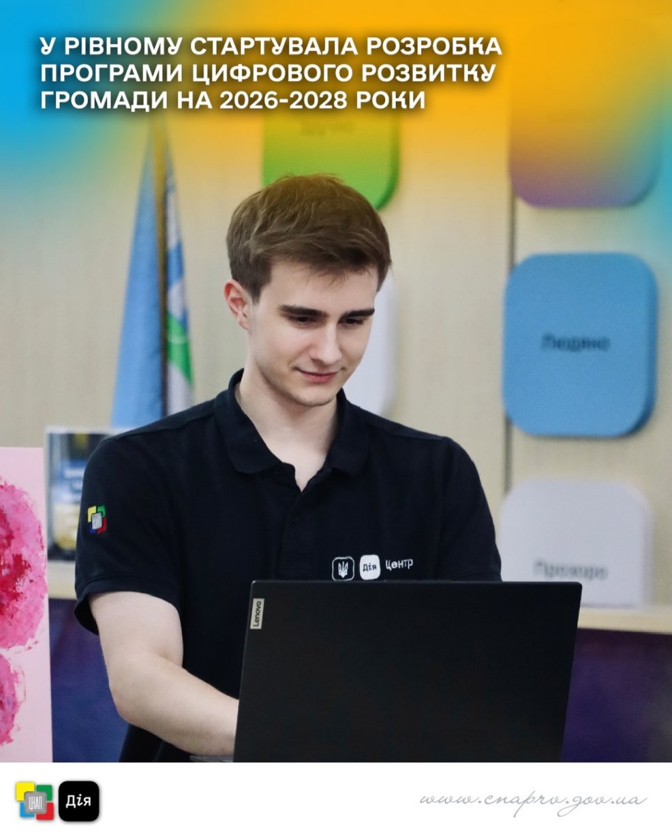 Хлопець у чорному одязі працює за комп'ютером.