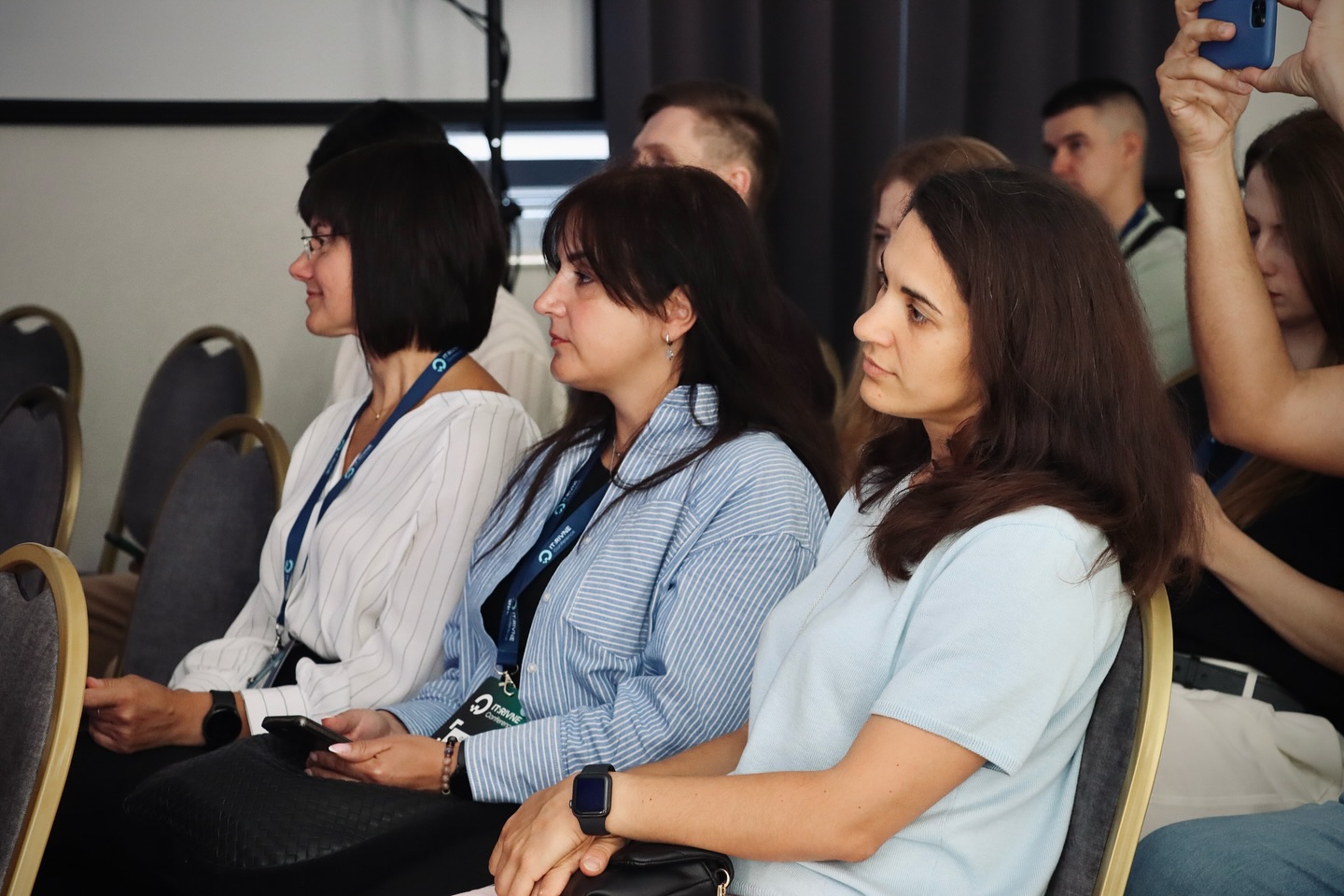 Три жінки сидять у приміщенні.