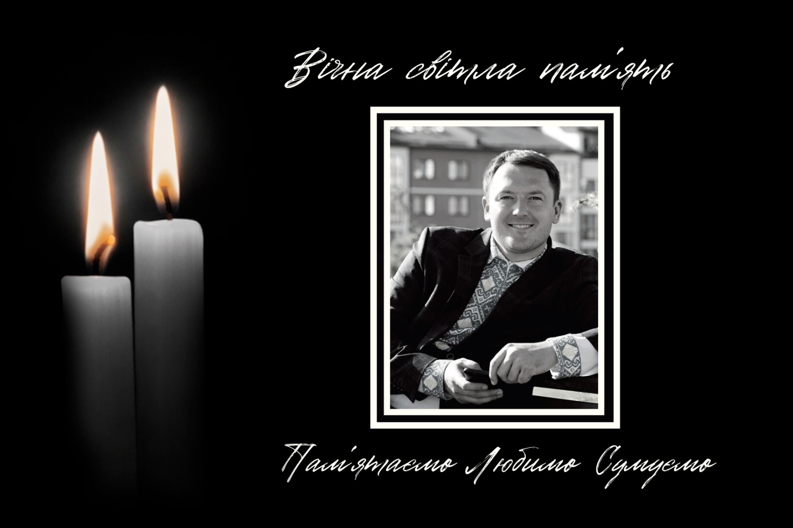 Чорнобіле фото усміхненого чоловіка та дві свічки поруч