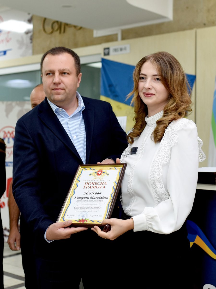 Чоловік та жінка позують з грамотою у руках.