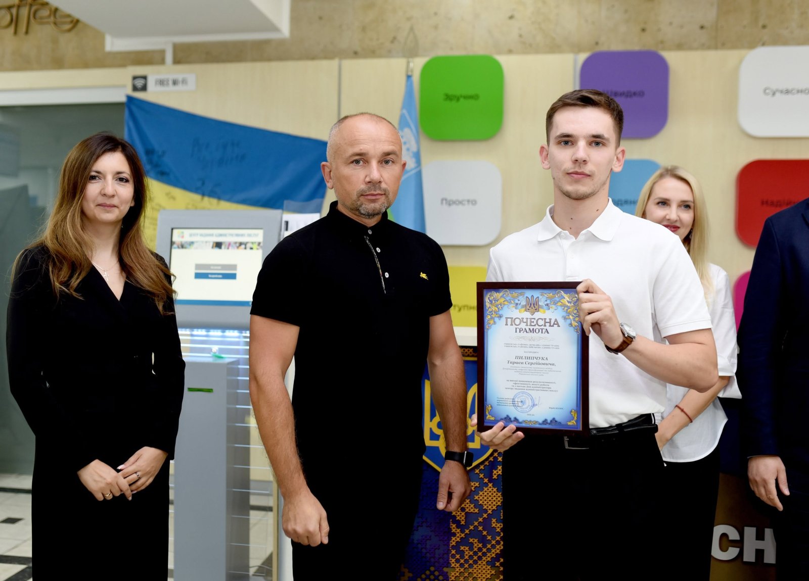 Двоє чоловіків позують з грамотою.