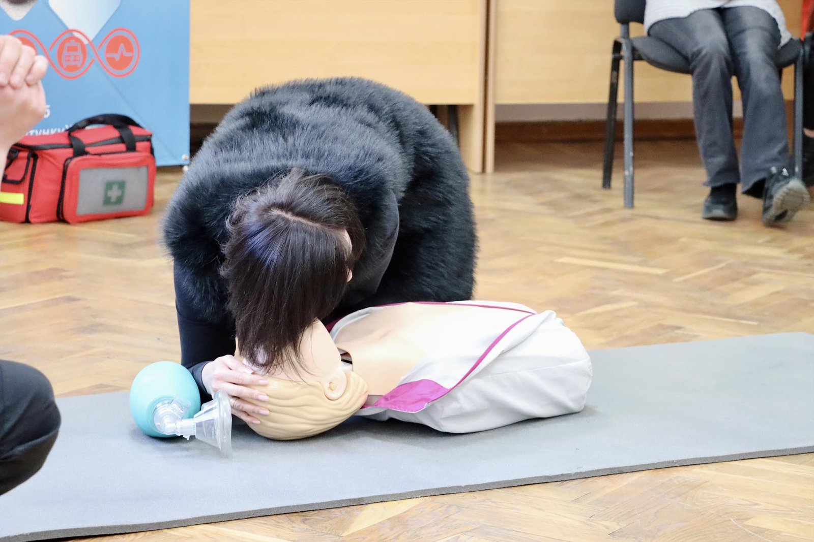 Жінка перевіряє дихання на манекені