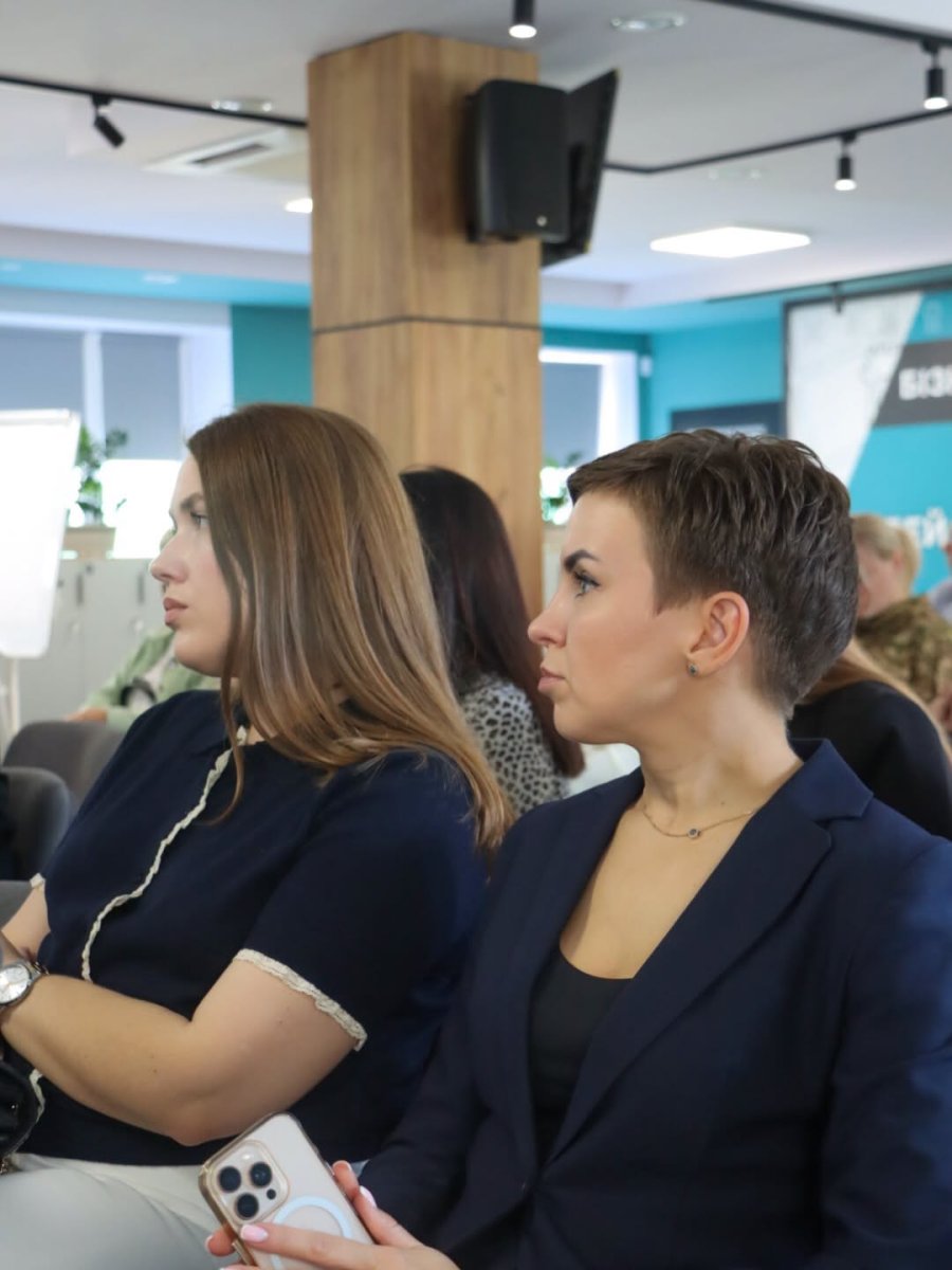 Дві жінки сидять у приміщенні.
