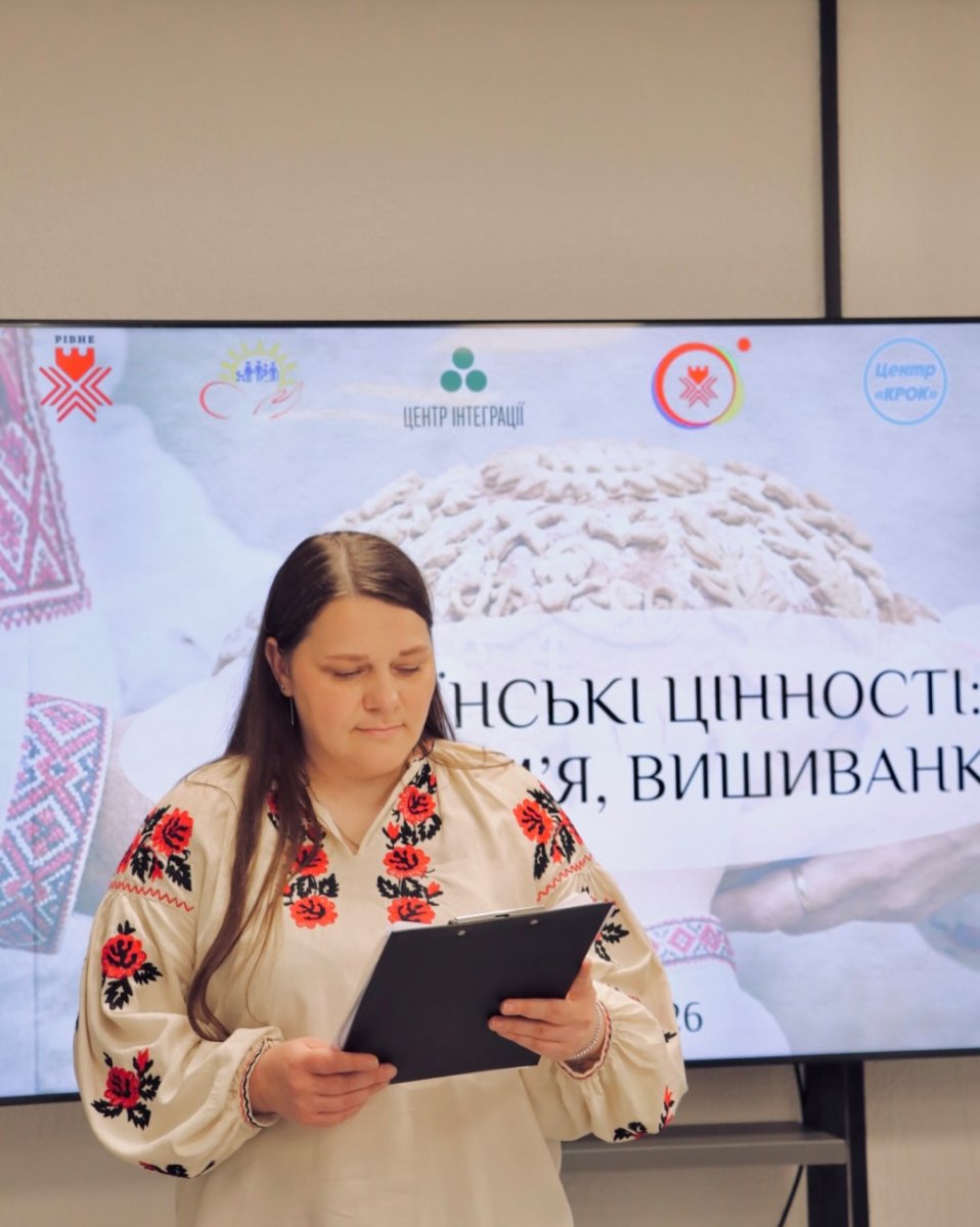 Жінка у вишиванці тримає чорну папку.
