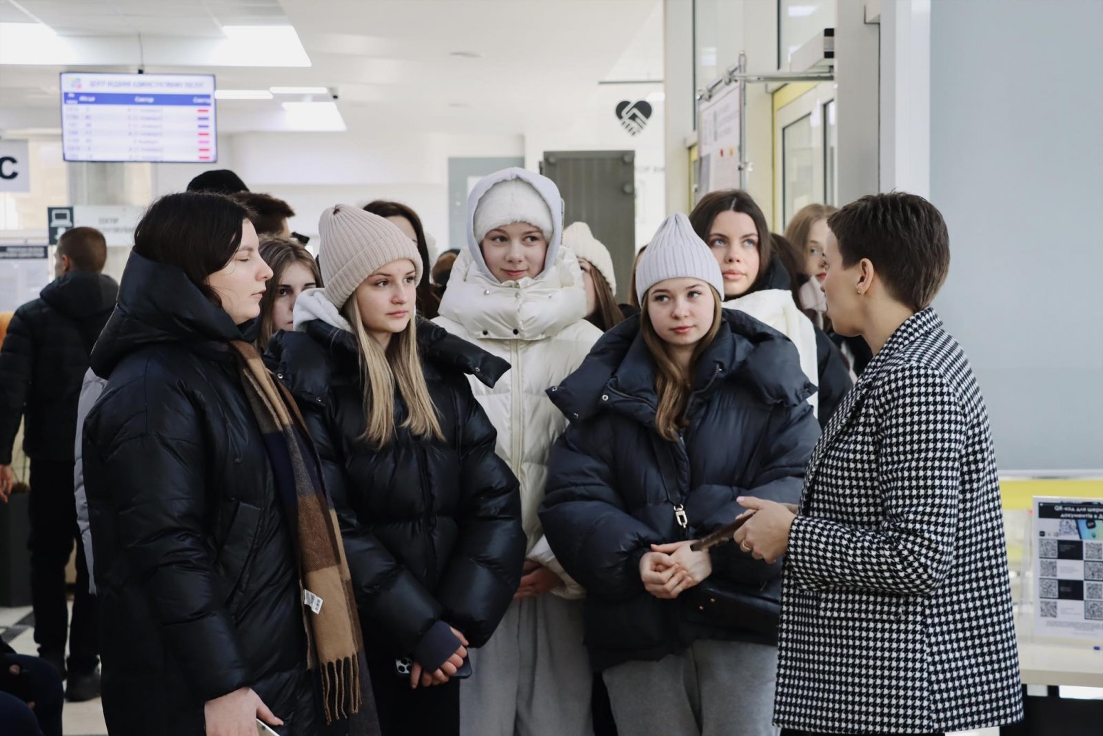 Жінкау діловому одязі щось розповідає групі людей.