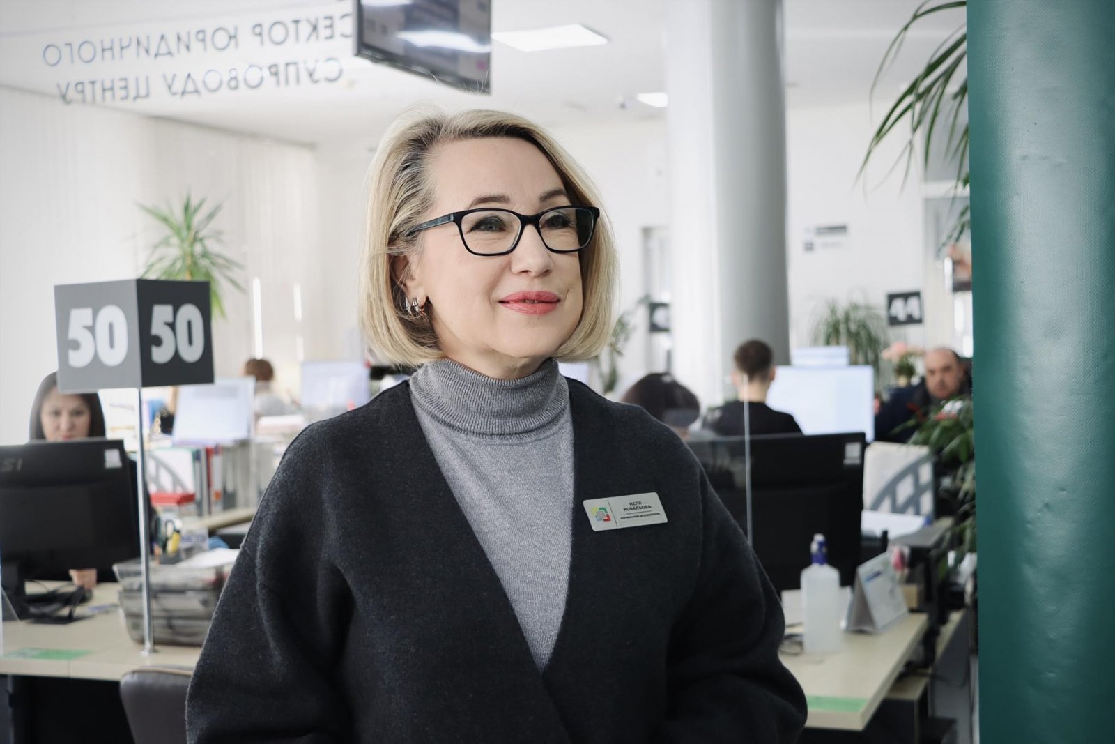 Жінка зі світлим волоссям в окулярах.