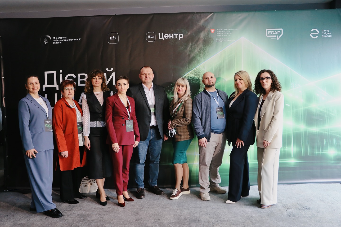 Групове фото людей на фоні банера.