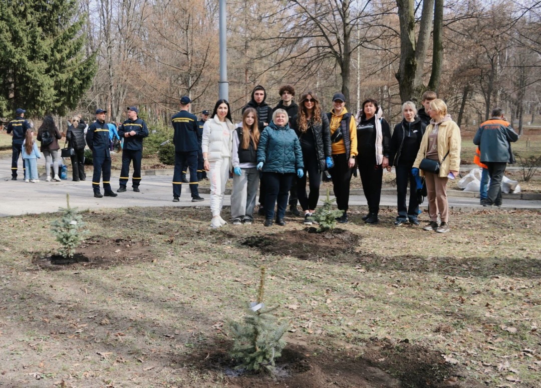 Група людей стоять біля садженця.