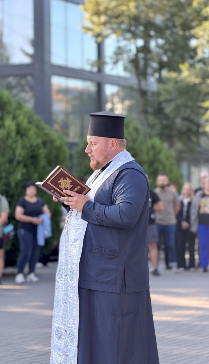 Священник тримає книгу у руках.