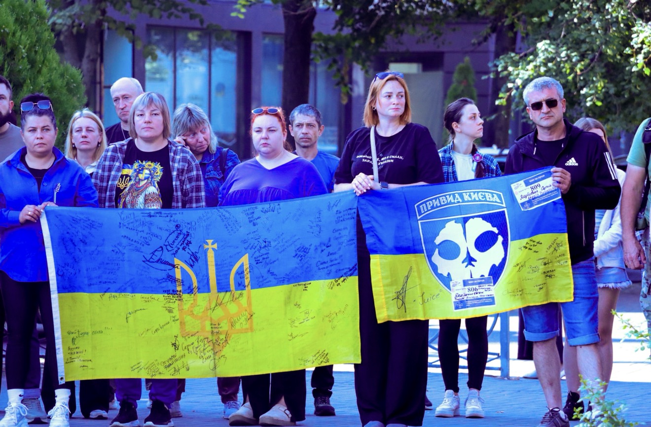 Люди тримають прапори України у руках.