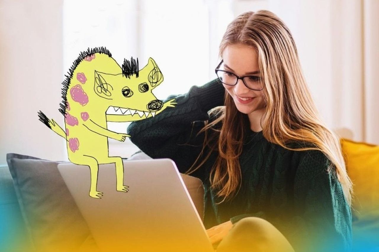 Дівчина з ноутбуком усміхається, поруч намальований кумедний монстр.