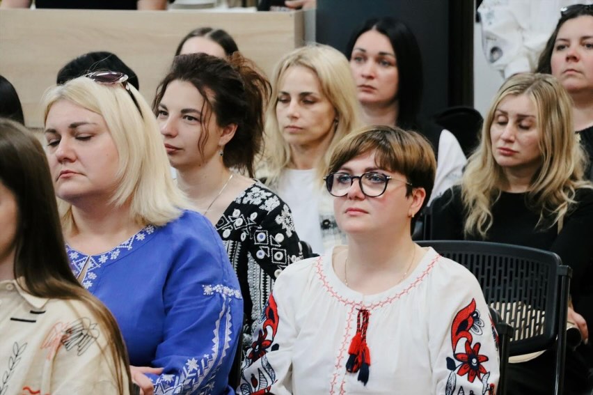 Багато жінок сидять у залі.