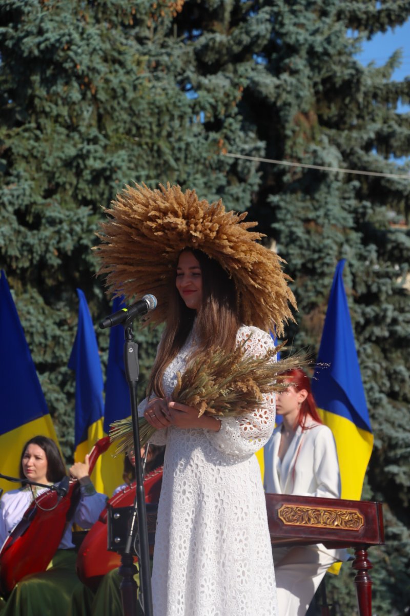 Жінка у вишиванці у вінку з колосся пшениці.