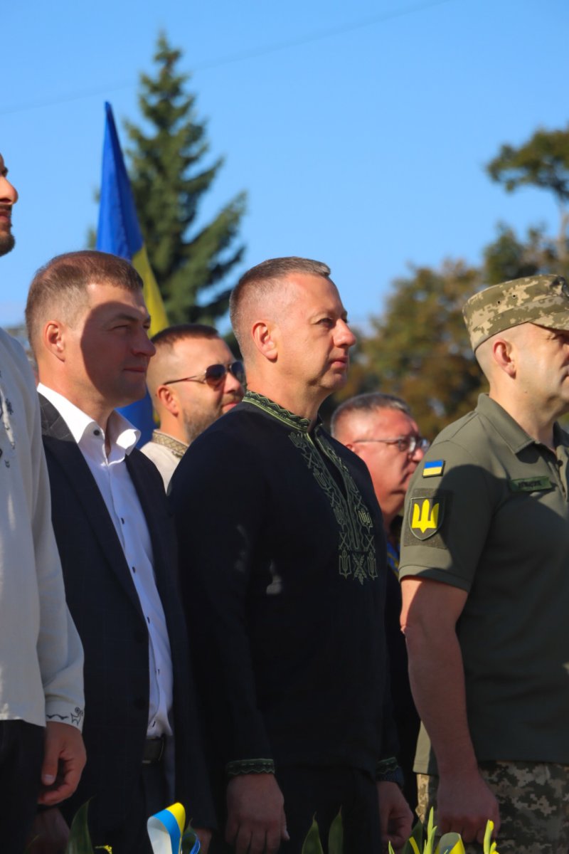 Чоловіки у вишитій сорочці стоять надворі.