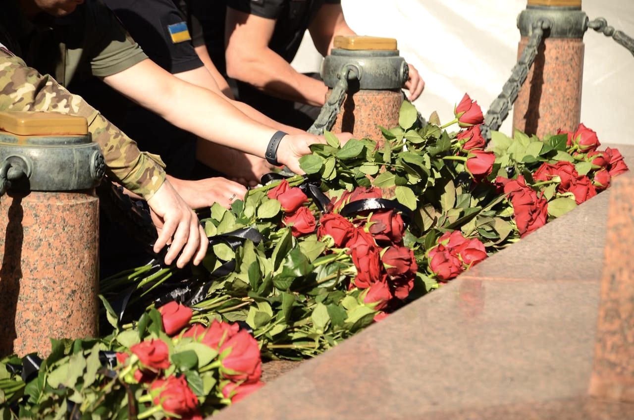 Троянди червоного кольору кладуть на землю.