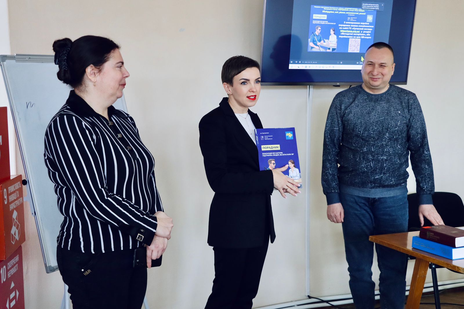 Чоловік та двоє жінок перебувають у приміщенні.