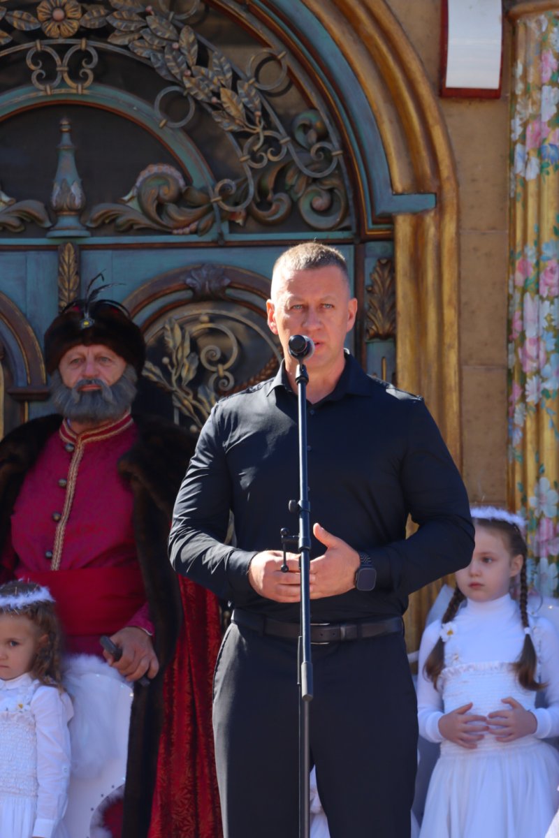 Чоловік у чорній сорочці стоїть біля мікрофону.