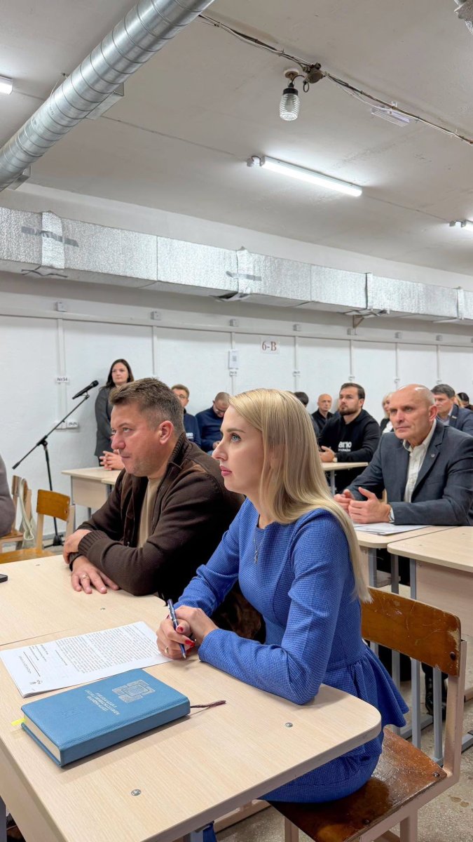 Люди сидять у приміщенні.