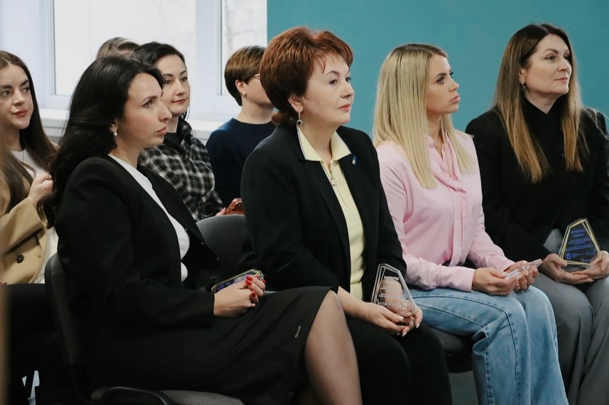 Група жінок сидять у приміщенні.