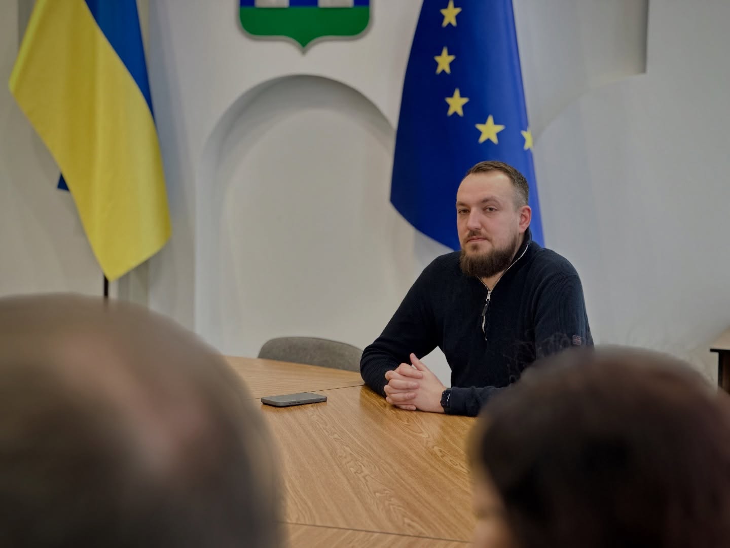 Чоловік з бородою сидить за столом