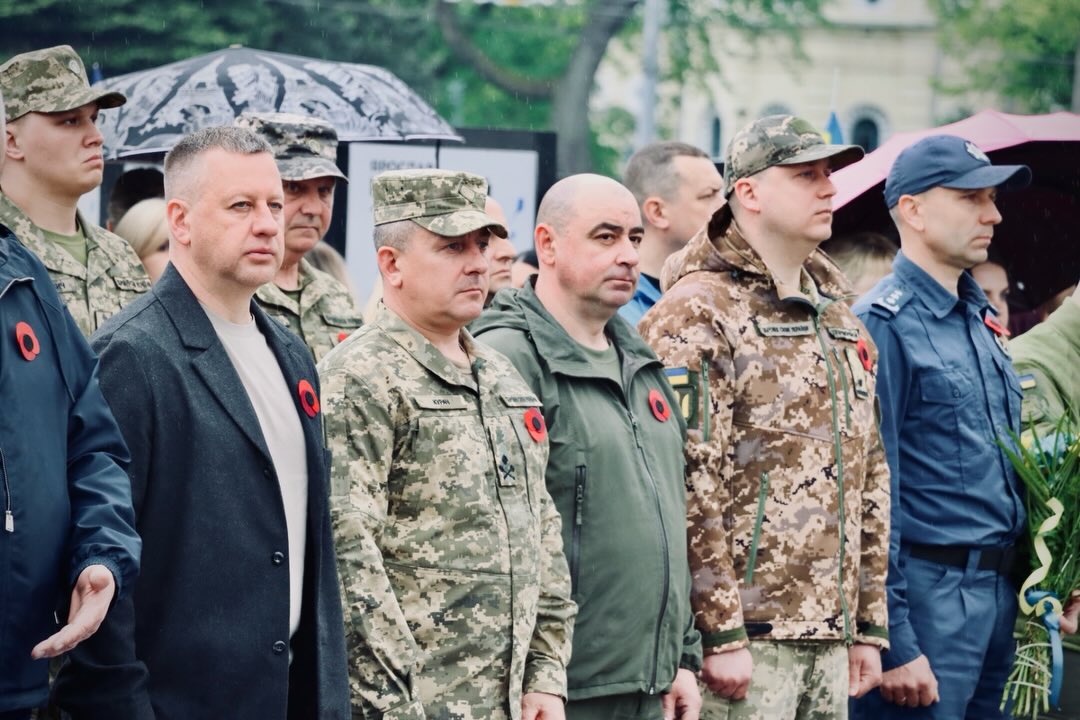 Чоловіки у військовій формі перебувають надворі.