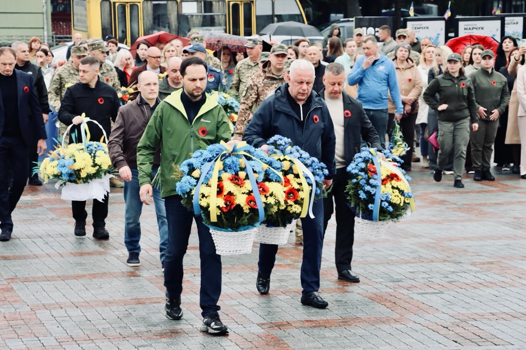 Чоловіки несуть корзини з квітами.